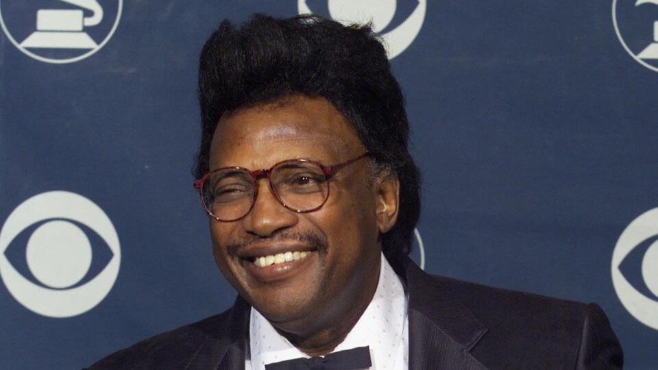 Le guitariste et chanteur Otis Rush pose devant des photographes lors de la soirée des prix Grammy de 1999, un trophée dans les mains.