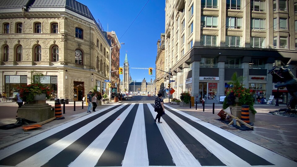 Les piétons marchent sur les lignes blanches d'une chaussée.