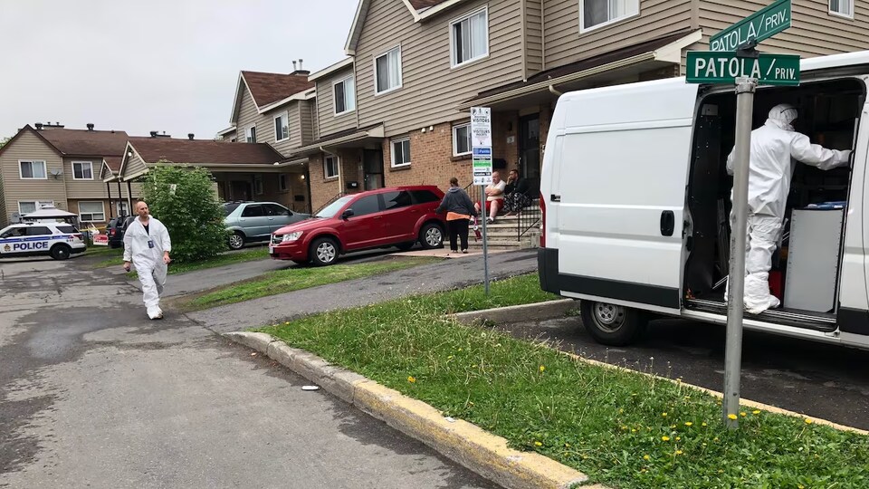 Une équipe de policiers devant une maison.