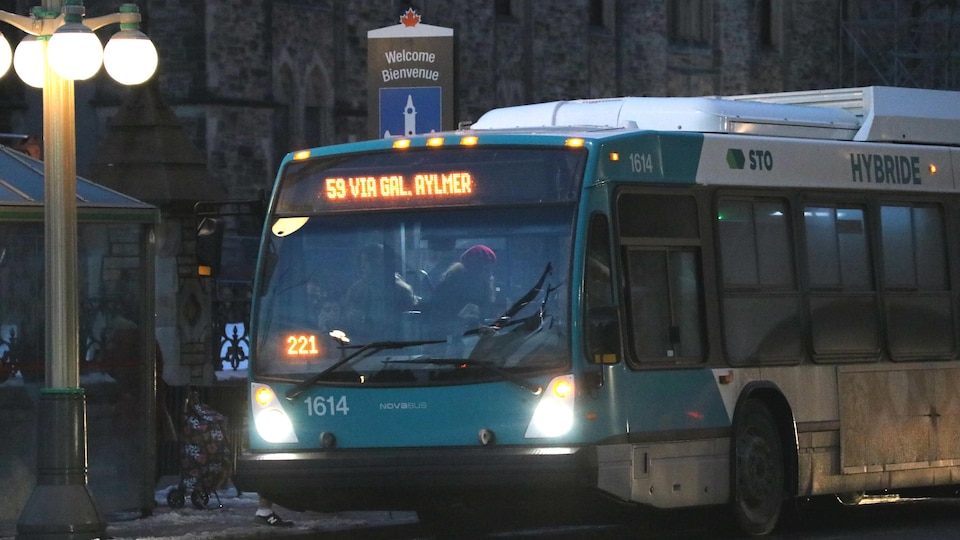 Un autobus du circuit 59 de la STO sur la rue Wellington à Ottawa en début de soirée, en hiver. 