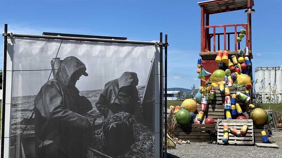Des bouées maritimes sont attachées sur une structure en bois, à l'extérieur.