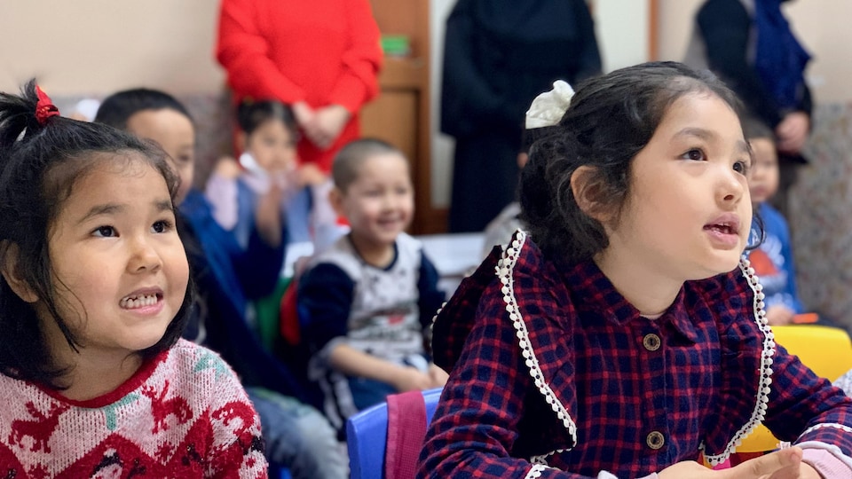 Des enfants assis à un pupitre.