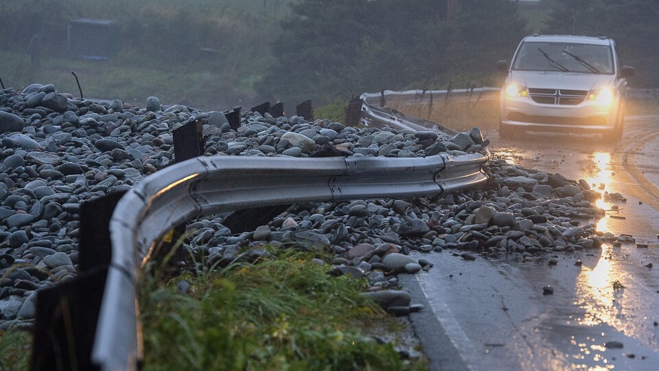Un garde-fou poussé sur la route par les vagues.