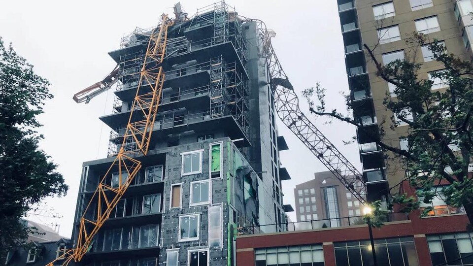 Une grue tombée sur le toit d'un immeuble en construction.