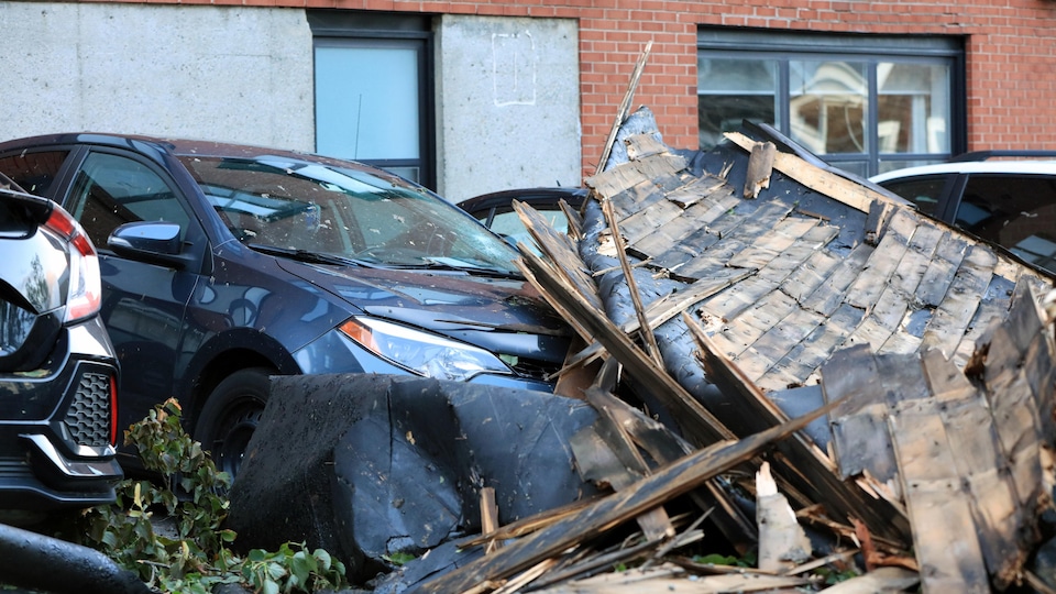 Un véhicule endommagé par un large morceau de toiture tombé durant l'ouragan.