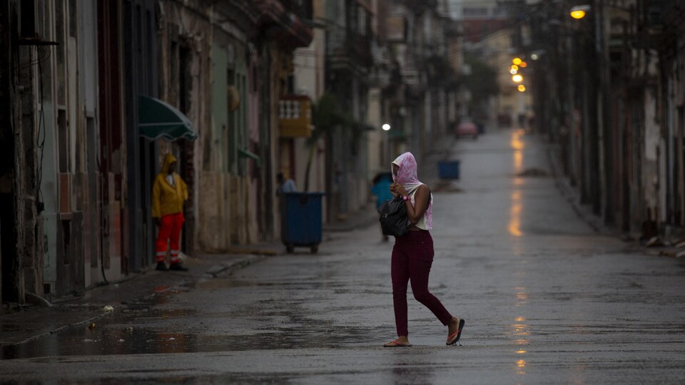 Une femme traverse une rue vide lors du passage de l'ouragan Ian à La Havane.