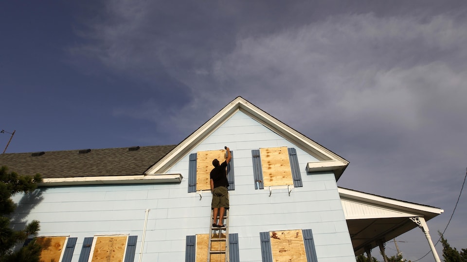 Un résident de Cape Hatteras, en Caroline du Nord, se prépare au passage de l'ouragan Irene, en août 2011, en barricadant les fenêtres de sa maison.