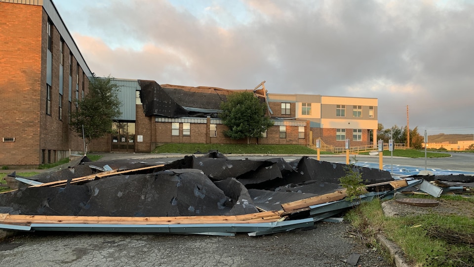 Le toit d'une école est effondré sur le stationnement. 