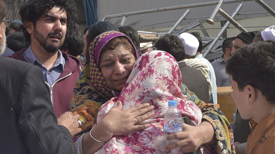 Des Pakistanais pleurent la mort de leurs proches. 