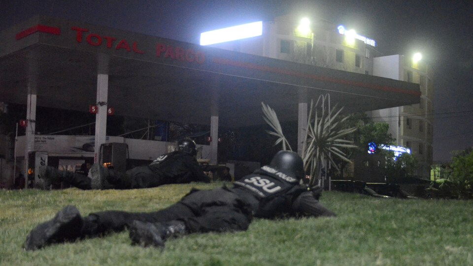 Des policiers rampent vers le complexe.