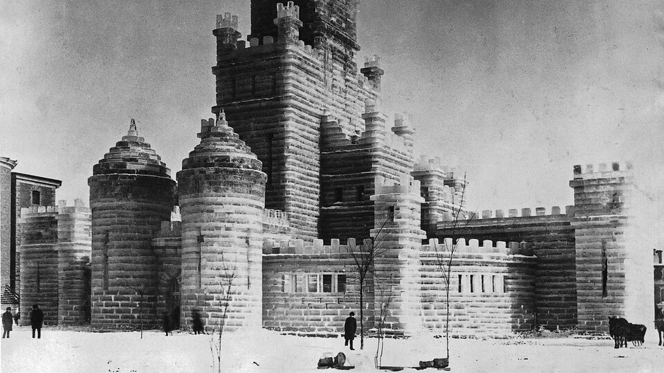 Quelques passants semblent minuscules auprès d'un énorme château de glace
