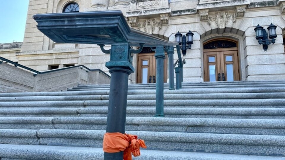 Le mémorial pour les Autochtones érigé sur les marches du palais législatif de la Saskatchewan a été vidé. Il ne reste plus qu'un tissu orange accroché à une rampe.
