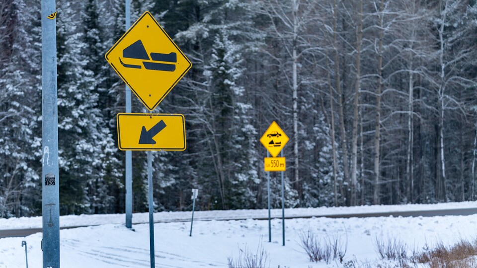 Une pancarte indiquant la présence d'une traverse de motoneige sur une route dans un secteur boisé de la Mauricie.