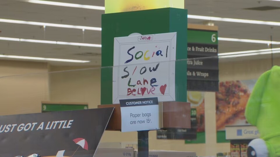 Une pancarte désigne une des caisses de paiement du magasin Sobeys d'Edmonton comme voie lente.