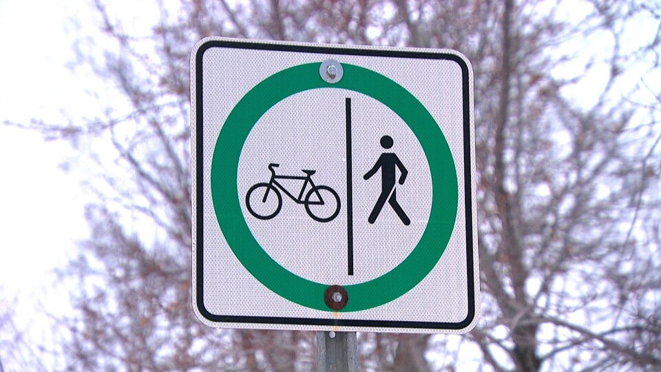 La pancarte présente l'icône d'un vélo et celle d'un piéton, les deux entourées d'un cercle vert.