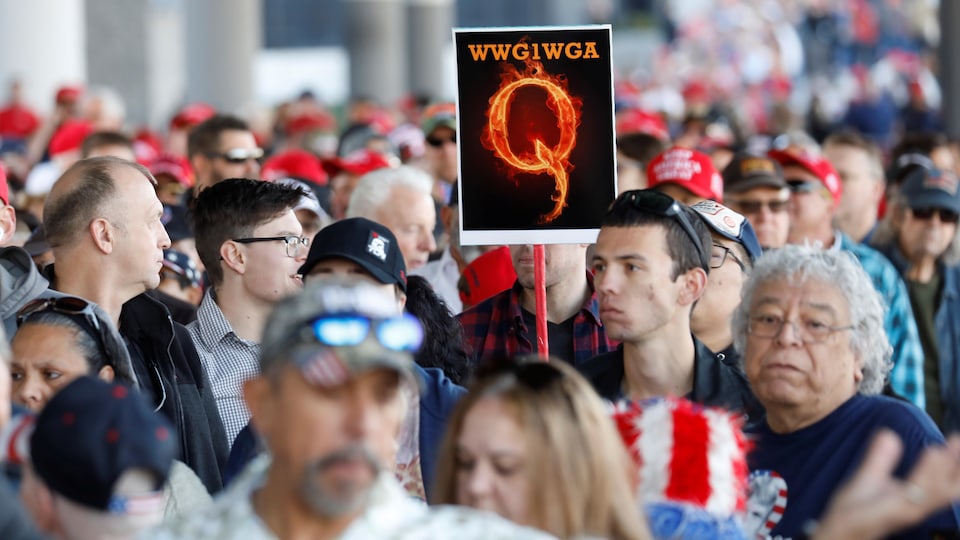 A man in the crowd holds a QAnon sign with the group's abbreviation of their rallying cry "Where we go one, we go all" as crowds gather to attend U.S. President Donald Trump's campaign rally at the Las Vegas Convention Center in Las Vegas, Nevada, U.S., February 21, 2020. REUTERS/Patrick Fallon