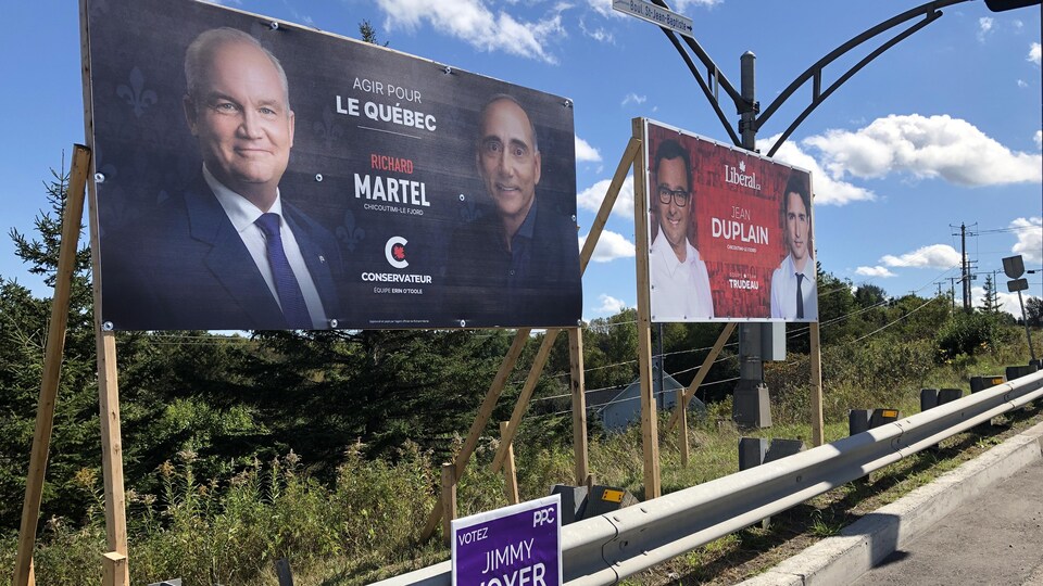 Des pancartes électorales le long d'une route.
