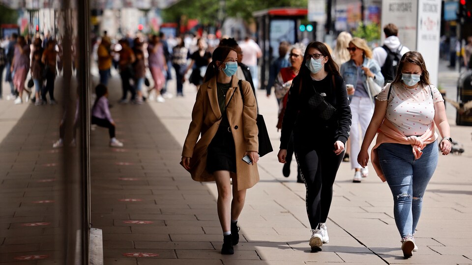 Des piétons portant des masques en raison de la pandémie de COVID-19, marchent le long d'Oxford Street dans le centre de Londres.