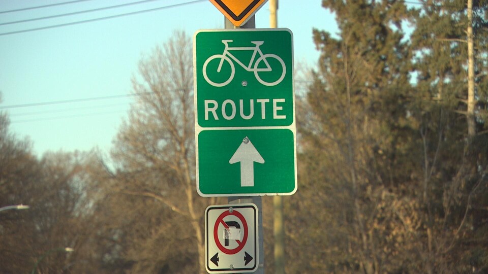 Un panneau vert avec une bicyclette.