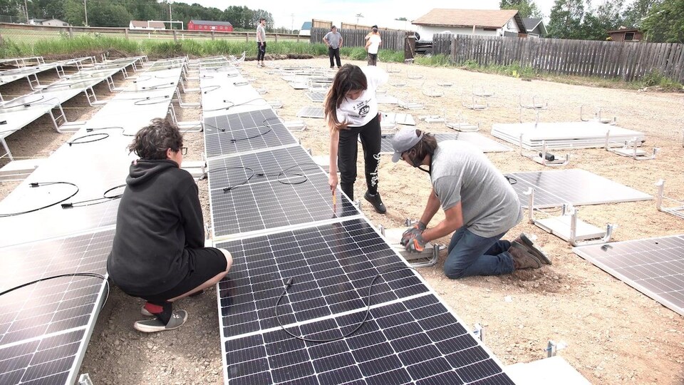 Des élèves du secondaire d'Île-à-la-Crosse installent des panneaux solaires.