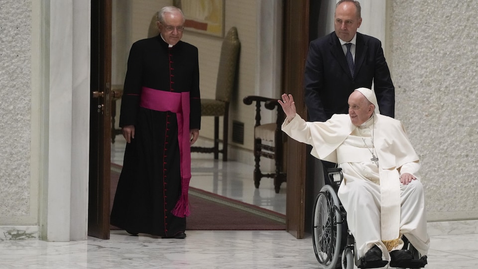 Le pape François entre en fauteuil roulant dans la salle Paul VI au Vatican.