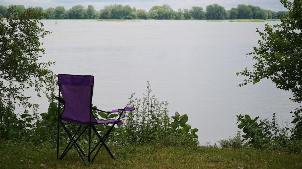 Une chaise de camping devant le fleuve.