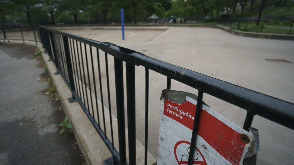 Une affiche sur une clôture du parc Jeanne-Mance indique que la pataugeoire est fermée.