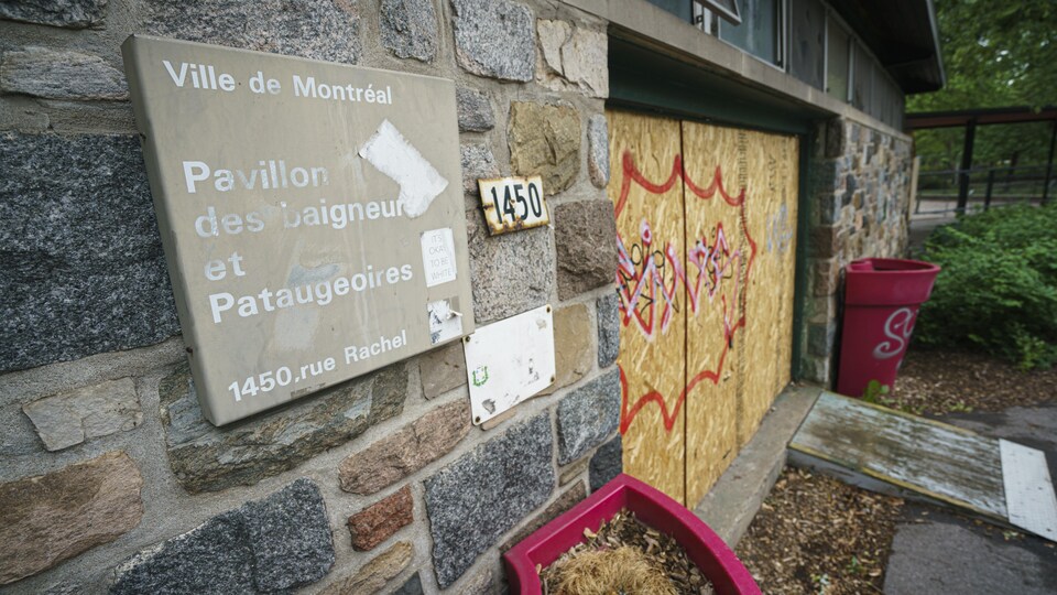 Un écriteau sur un bâtiment en brique de la Ville de Montréal, sur lequel on peut lire : Pavillon des baigneurs et Pataugeoires.