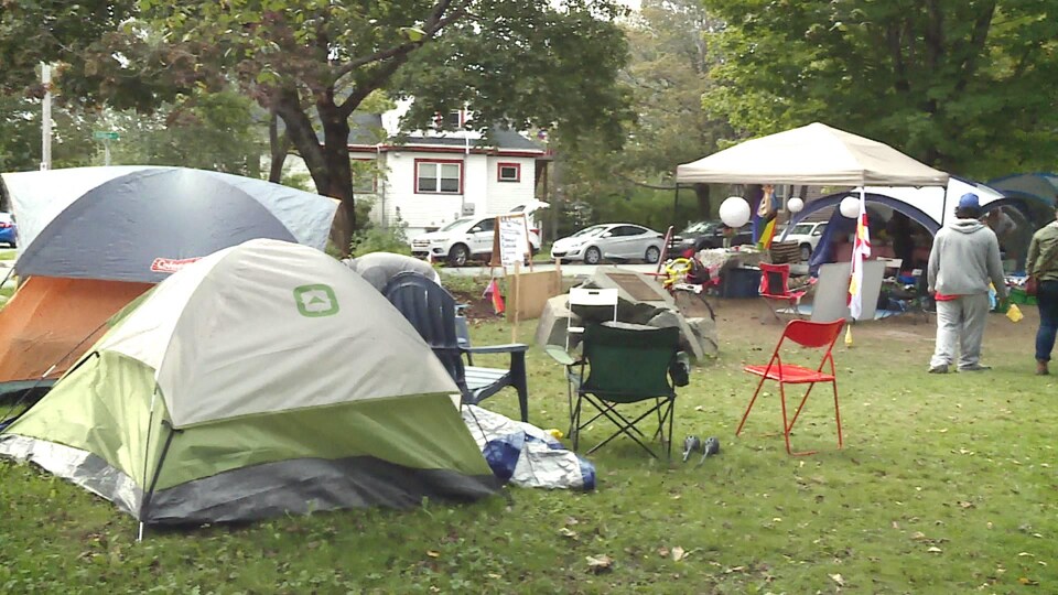 Des tentes et des campements de personnes sans-abri dans un parc.
