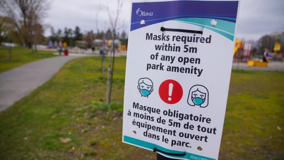 Une affiche de la Ville d'Ottawa sur laquelle on peut lire que le masque est obligatoire dans le parc.