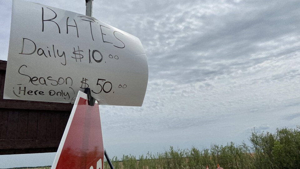 Une pancarte ou il est écrit tarifs : 10 dollars par jour, 50 dollars pour la saison.
