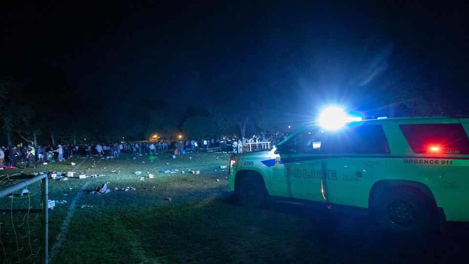 Une voiture de police devait des fêtards dans un parc la nuit.