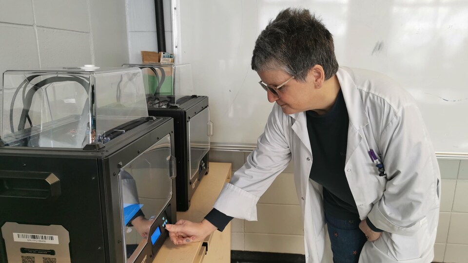 Une femme programme une imprimante 3D.
