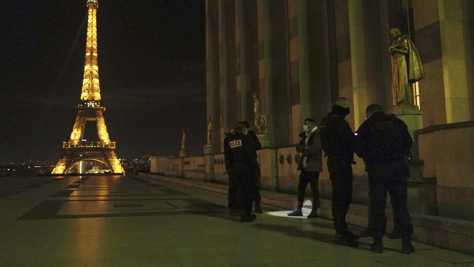 Des policiers français arrêtent une personne près de la tour Eiffel.