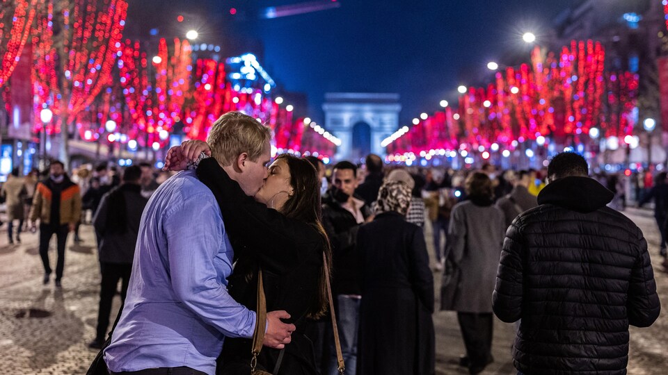 Un couple s'embrasse dans la foule à Paris.