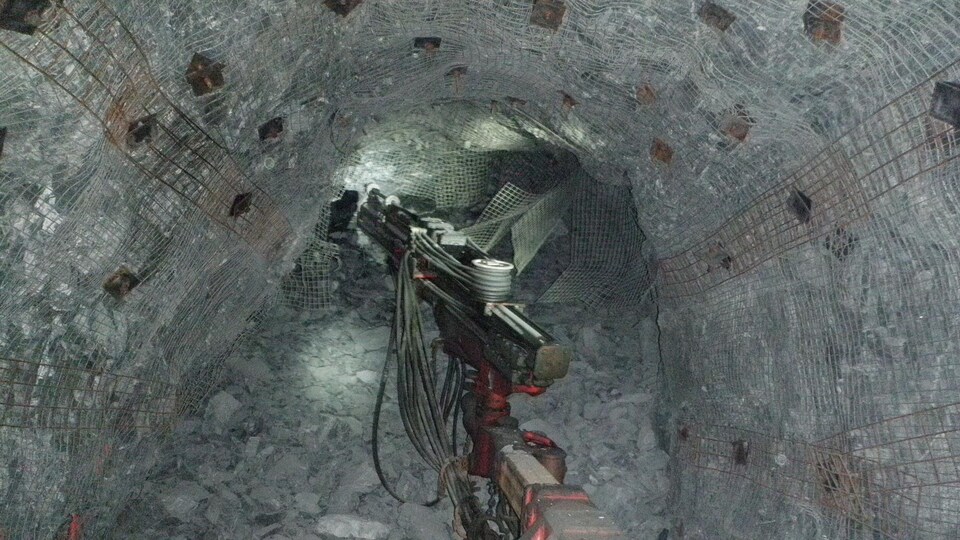 Une foreuse perce un trou dans la paroi d’une mine souterraine