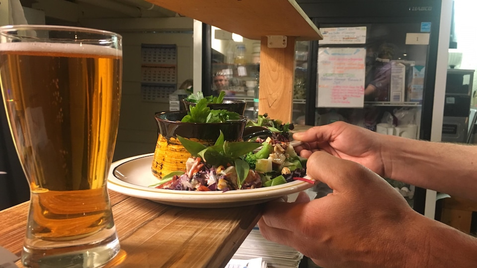 Gros plan d'une assiette de salade et d'une bière.