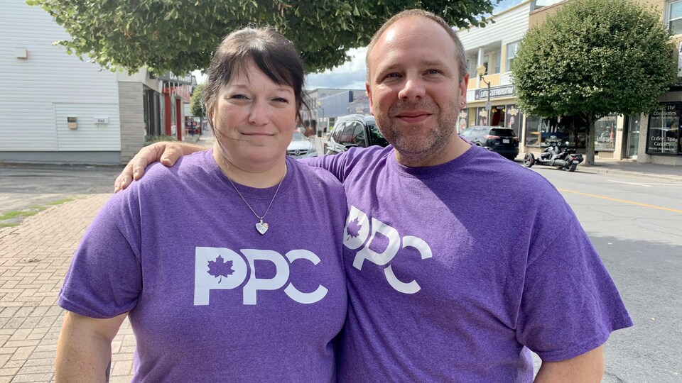 Deux personnes posent pour une photo dehors avec un chandail du Parti populaire du Canada.