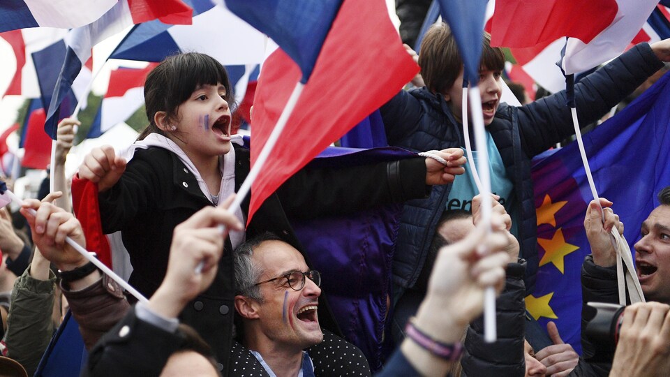 Des partisans français sont réunis pour célébrer avec enthousiasme la victoire d'Emmanuel Macron à la présidentielle de la France.