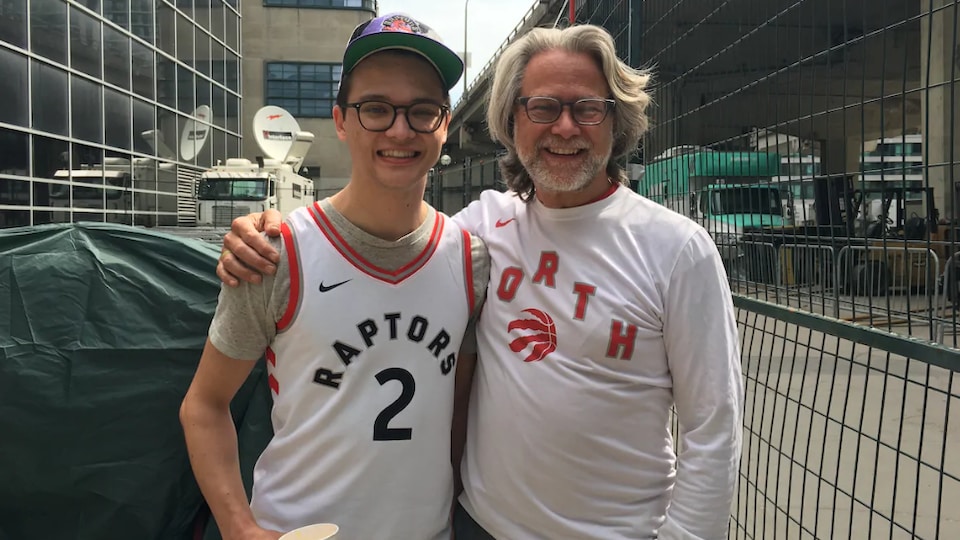 Un père et son fils qui portent des chandails des Raptors
