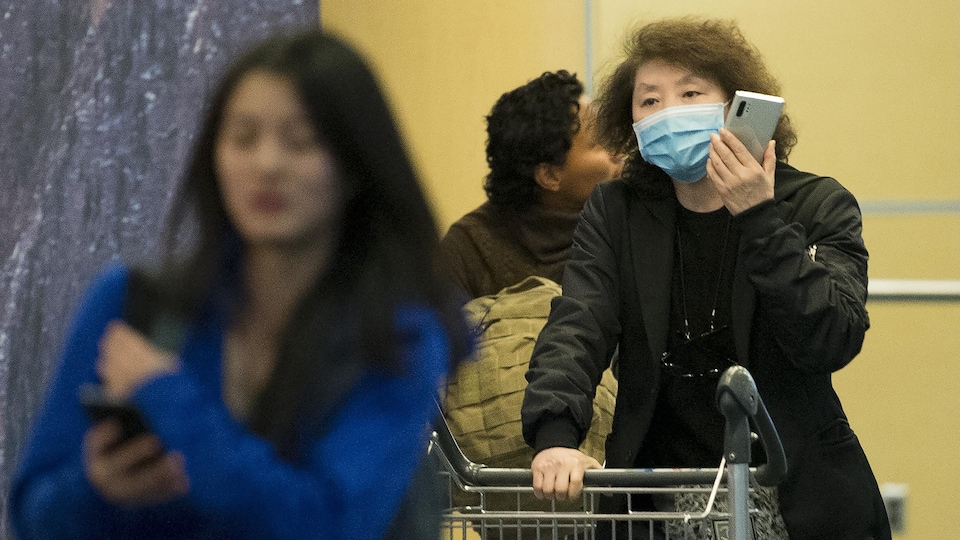 Une passagère porte un masque à son arrivée à l'aéroport de Vancouver.