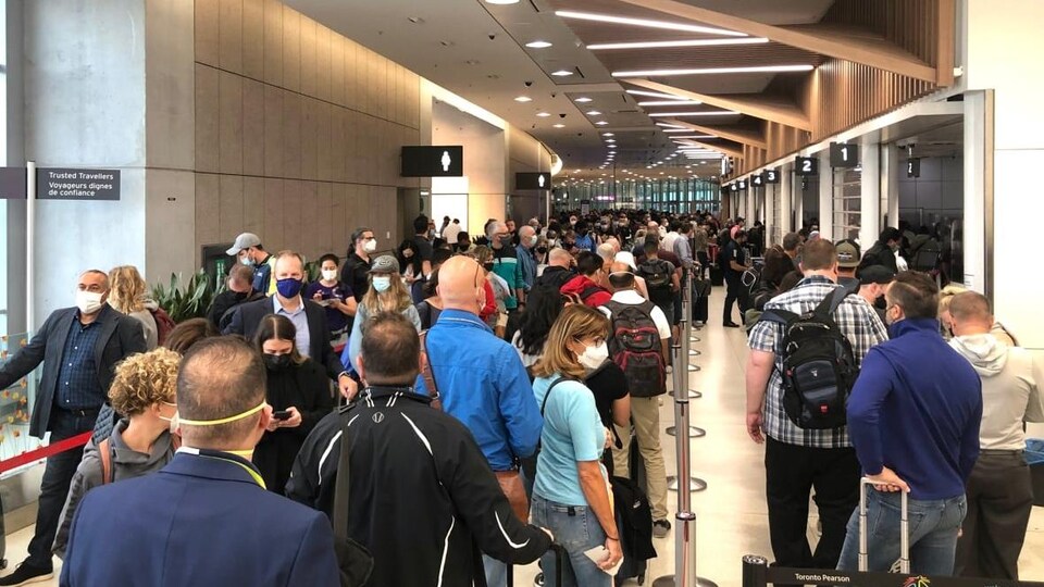 Une centaine de passagers qui attendent à l'aéroport.