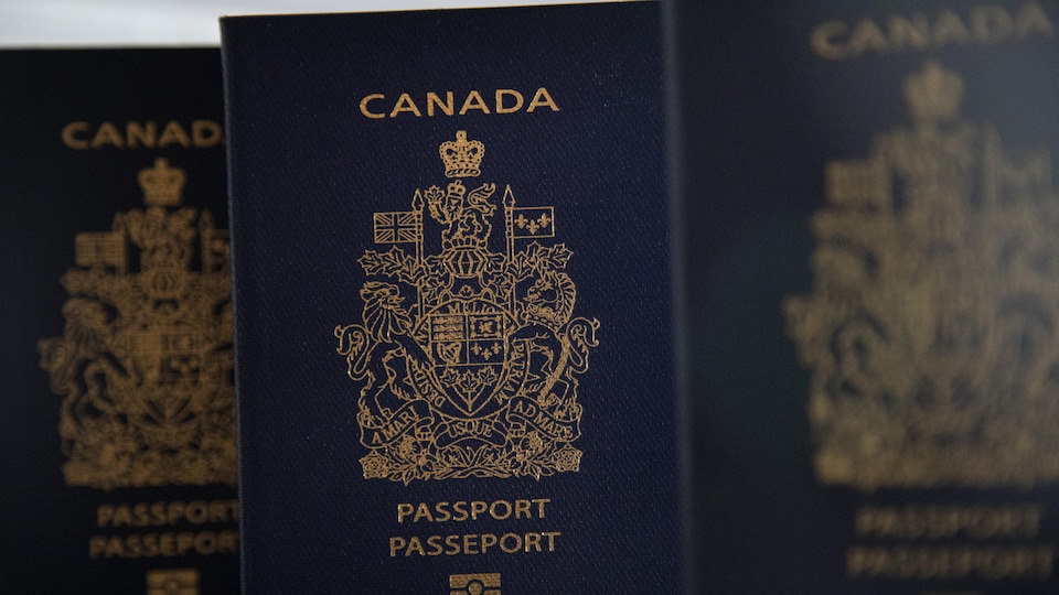 Des passeports canadiens dont on voit la couverture.