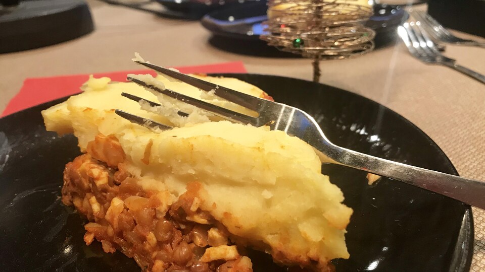 Une pointe de pâté dans une assiette avec une fourchette en gros plan.