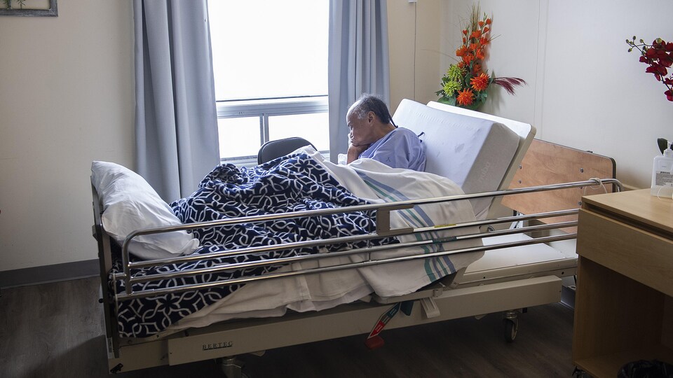 Un patient âgé dans un lit d'hôpital.