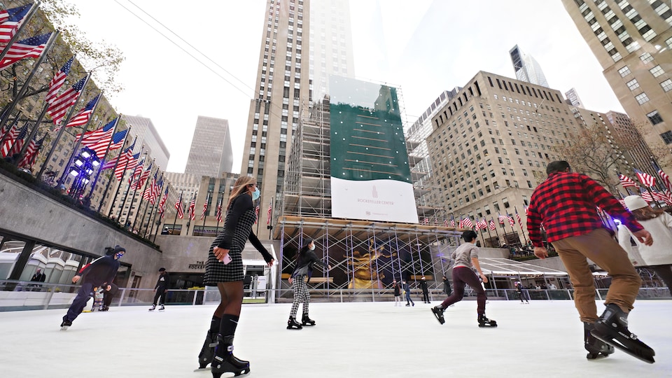 Des gens masqués patinent à distance au Rockefeller Center, le 21 novembre 2020.