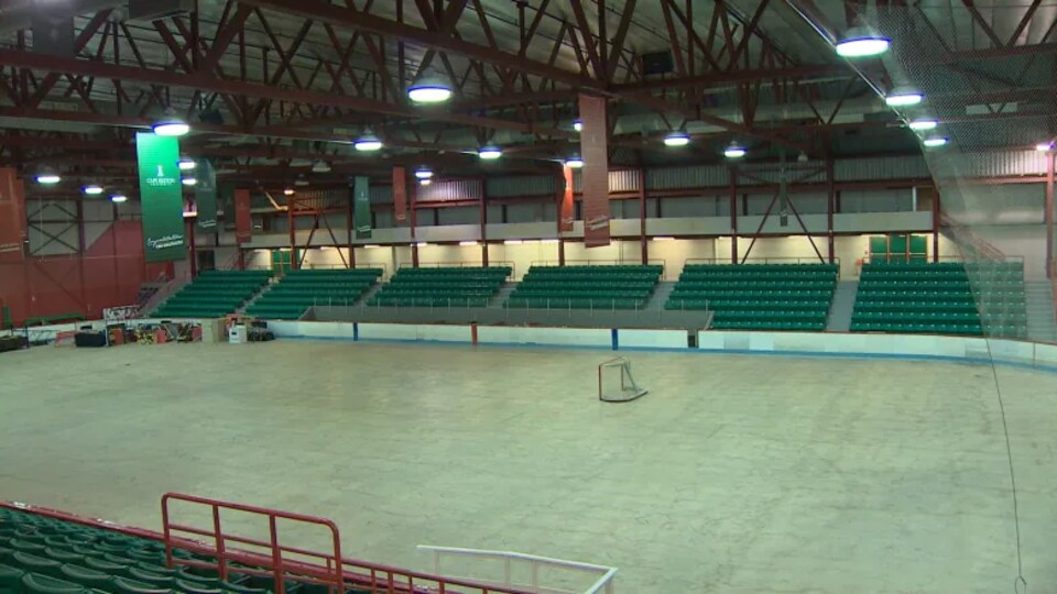 Un aréna vide et une patinoire sans glace.