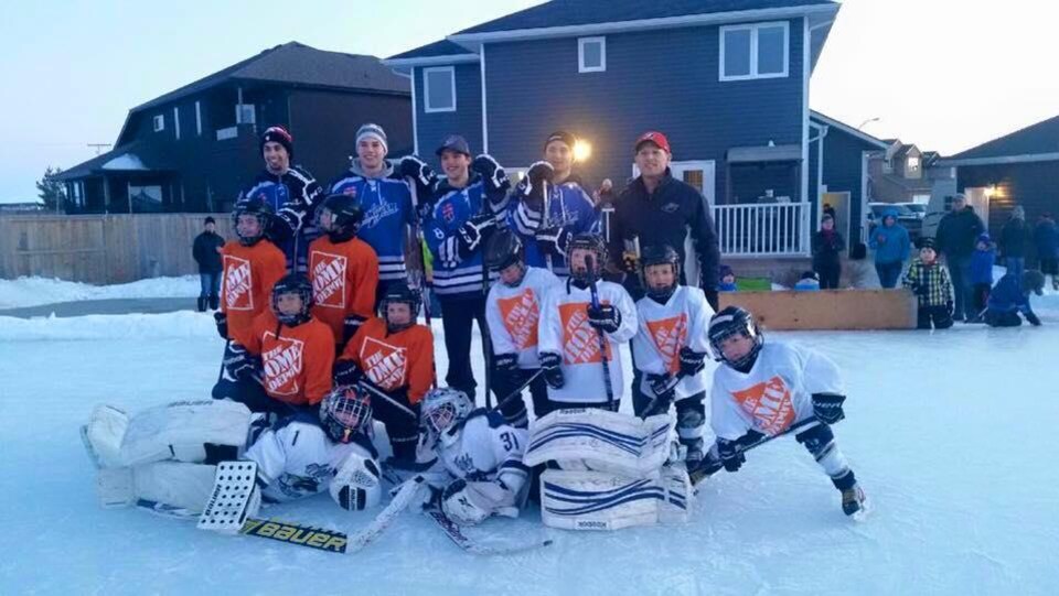 Des membres des Blades de Saskatoon jouent au hockey avec des enfants sur la patinoire de Jeff Clezy.