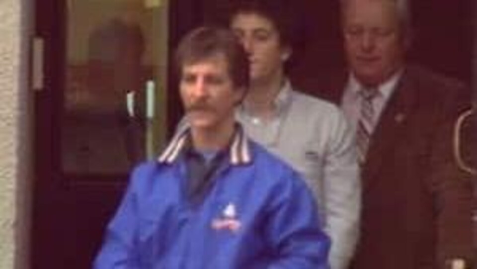 Trois hommes sortent d’une cour provinciale du Nouveau-Brunswick; la photo date de 1987.