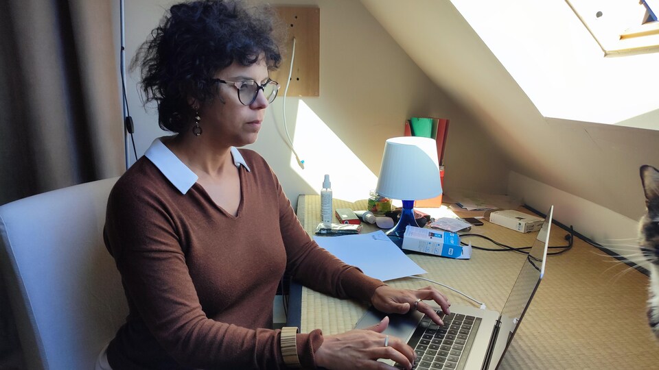 Patricia Clermont tape à l'ordinateur.